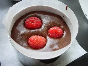 Half-cooked chocolate cake with raspberry coulis