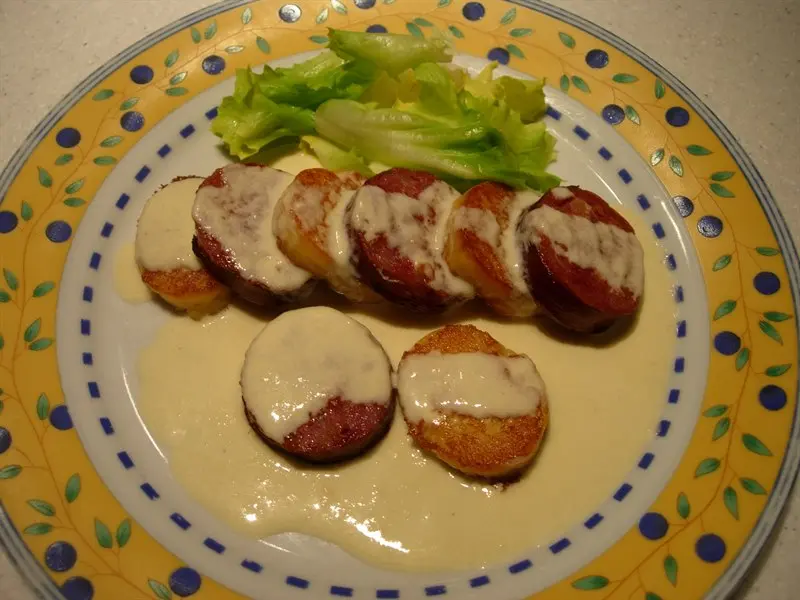 Sausage with duchess potatoes and a Mont d'Or fondue