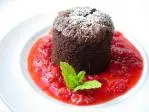 Half-cooked chocolate cake with raspberry coulis