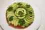 Puff pastry base with a disc of tomato jelly, topped with slices of lime-dressed avocado.