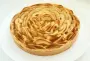 Apple tart with fresh fruit on a layer of compote in a shortcrust pastry base.