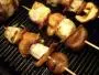 Kebabs alternating cubes of fish with mushrooms and bacon.