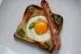 Fried bread with an egg-filled hole and a slice of bacon.