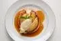 Circle of puff pastry with caramelized peaches, hot citrus sauce and vanilla ice cream.