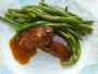Pork medallions in a spicy marinade, served with green beans and a reduced sauce.