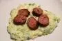 Mashed potato with cabbage and chives, served with baked sausages.